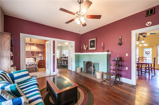 living room with ceiling fan with notable chandelier and dark wood-type flooring