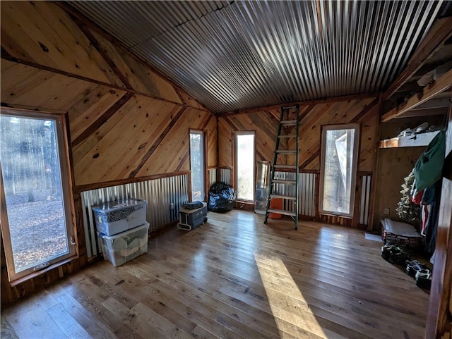 bonus room featuring wooden walls, vaulted ceiling, and dark hardwood / wood-style flooring