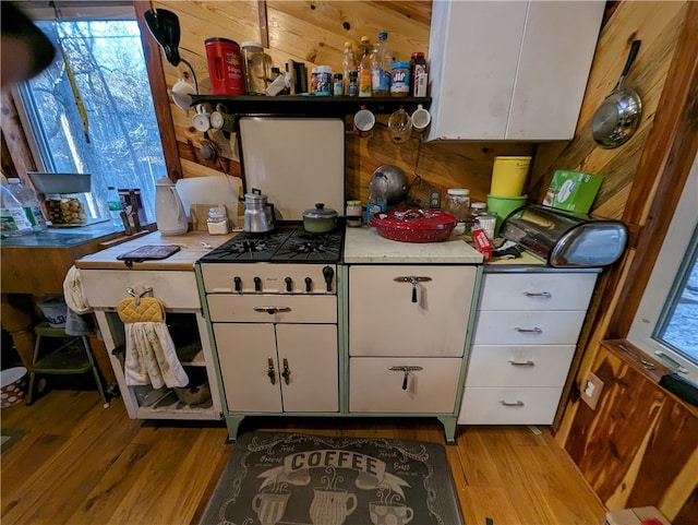 kitchen featuring white cabinets, a healthy amount of sunlight, and light hardwood / wood-style flooring