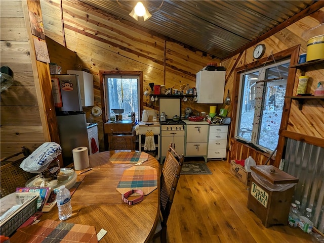 interior space featuring light hardwood / wood-style floors, wood walls, wooden ceiling, and vaulted ceiling