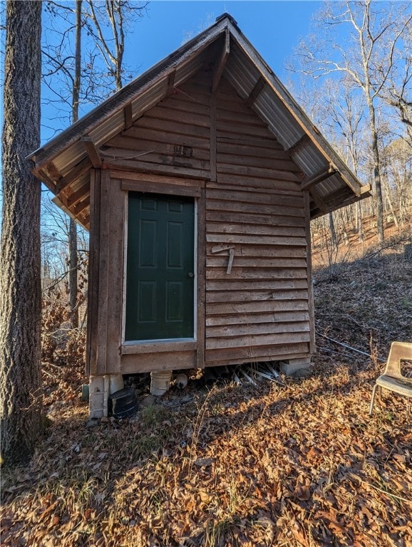 view of side of home featuring a storage shed