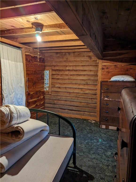 carpeted bedroom with wood ceiling, wood walls, and ceiling fan