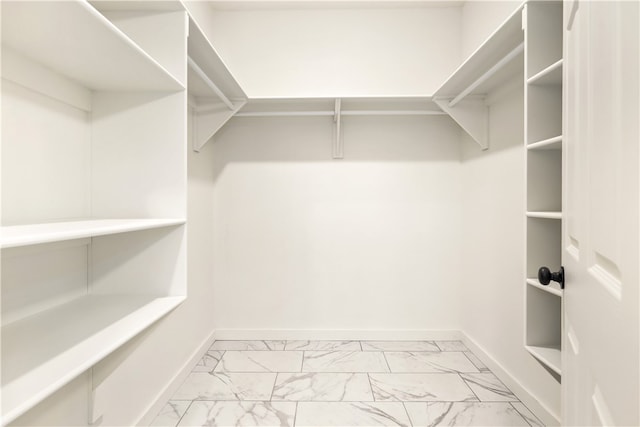 walk in closet with light tile flooring