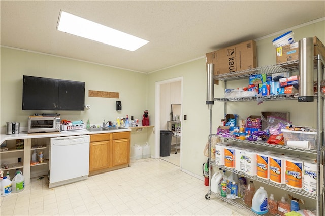 kitchen featuring light tile floors, white dishwasher, and sink