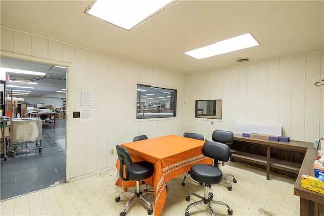 home office featuring light tile floors and wooden walls