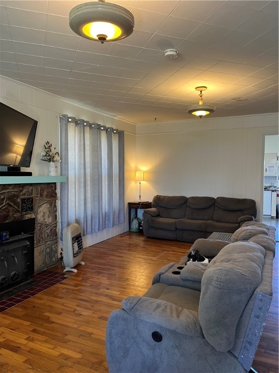 living room with a stone fireplace and hardwood / wood-style floors