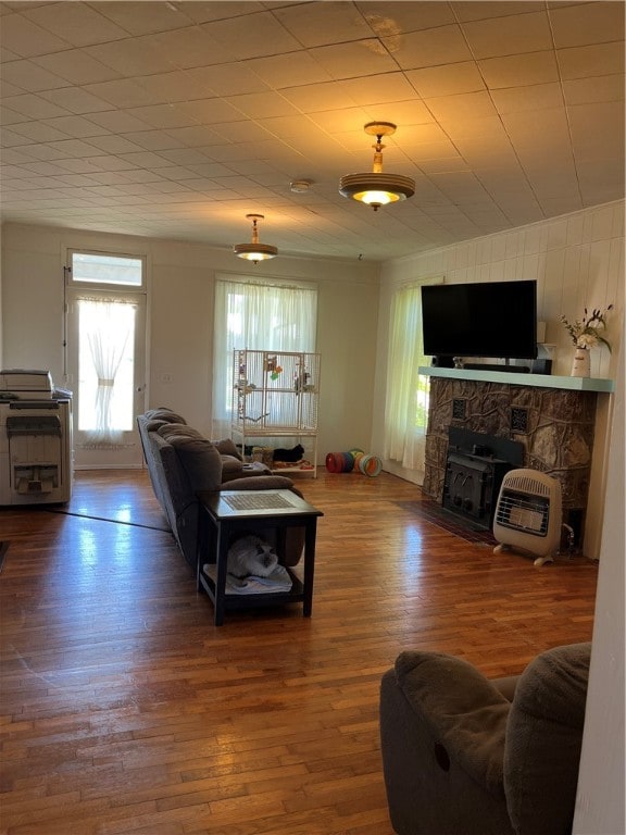 living room featuring a stone fireplace and hardwood / wood-style flooring