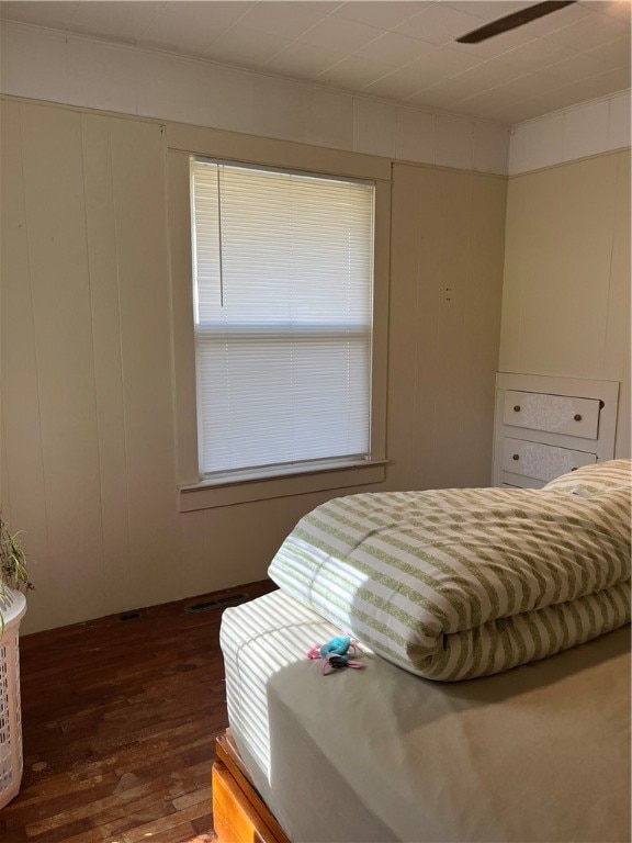 bedroom with dark hardwood / wood-style flooring and ceiling fan