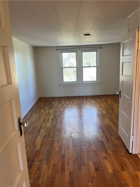 unfurnished room with dark hardwood / wood-style flooring