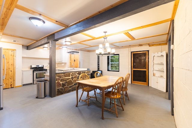 dining space with a chandelier, beam ceiling, concrete flooring, and sink