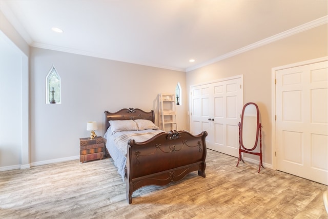 bedroom with crown molding, light hardwood / wood-style floors, and a closet