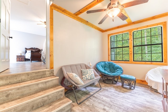 living area with crown molding, ceiling fan, and light wood-type flooring