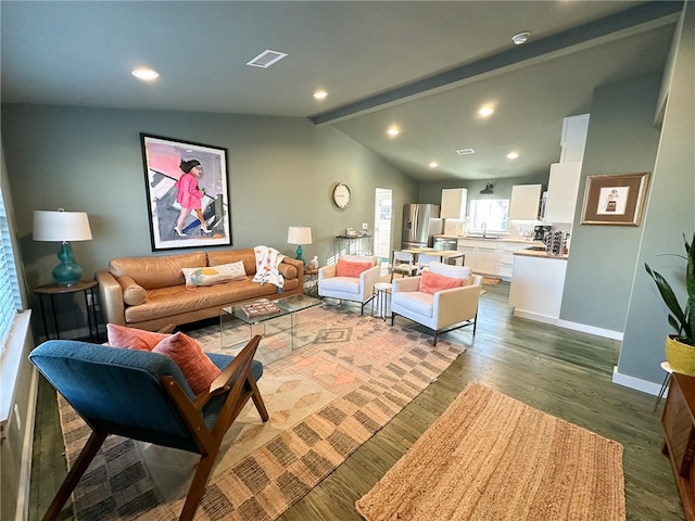 living room featuring vaulted ceiling with beams, sink, and light hardwood / wood-style flooring