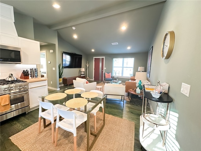 dining area featuring vaulted ceiling with beams and dark wood-type flooring