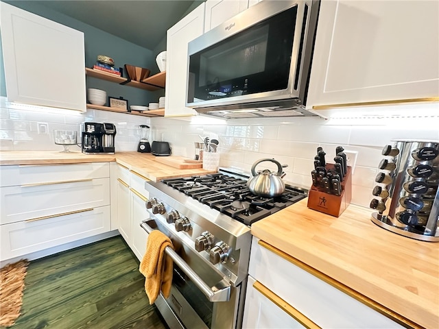 kitchen with backsplash, dark hardwood / wood-style floors, butcher block countertops, appliances with stainless steel finishes, and white cabinets