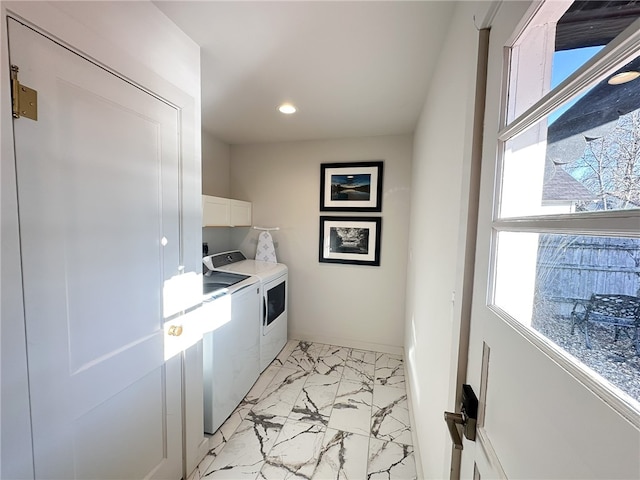 laundry area featuring cabinets, light tile floors, and washer and clothes dryer