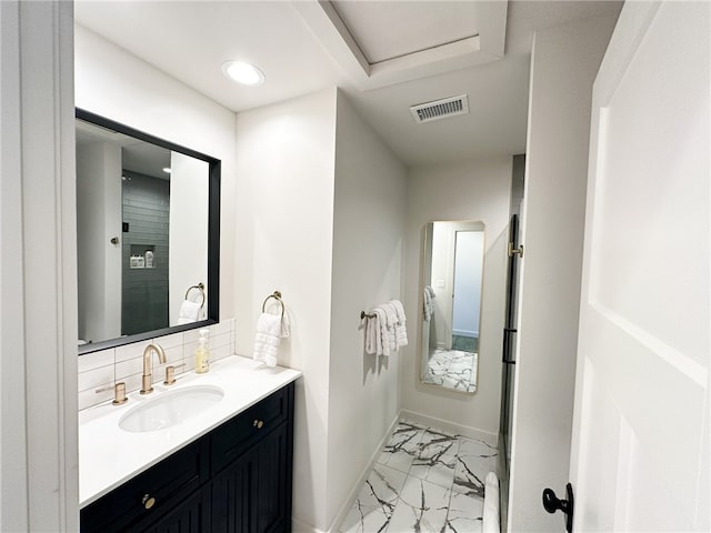 bathroom featuring vanity, tile flooring, and backsplash