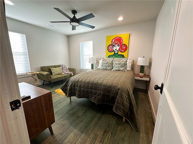 bedroom featuring ceiling fan, multiple windows, and dark hardwood / wood-style flooring