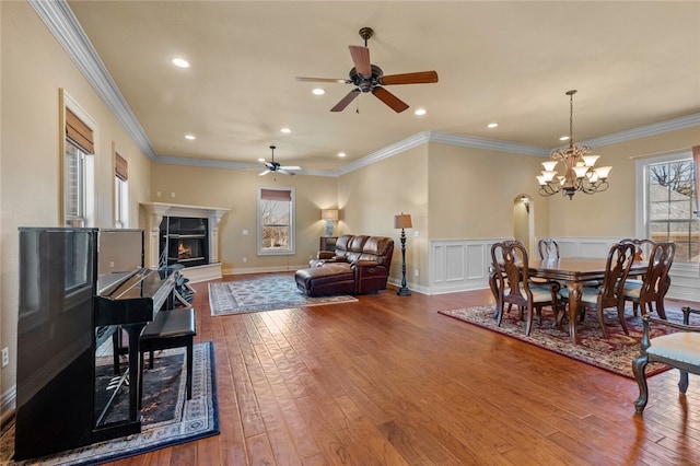 interior space featuring ornamental molding, light hardwood / wood-style flooring, and ceiling fan with notable chandelier