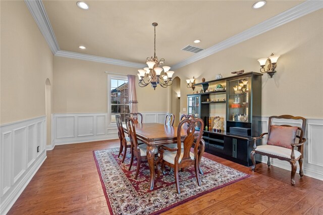 dining space with a chandelier, dark hardwood / wood-style floors, and ornamental molding