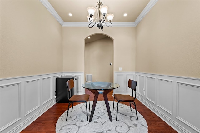 dining room featuring an inviting chandelier, ornamental molding, and dark hardwood / wood-style floors