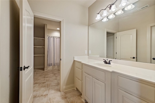 bathroom with tile flooring and vanity with extensive cabinet space