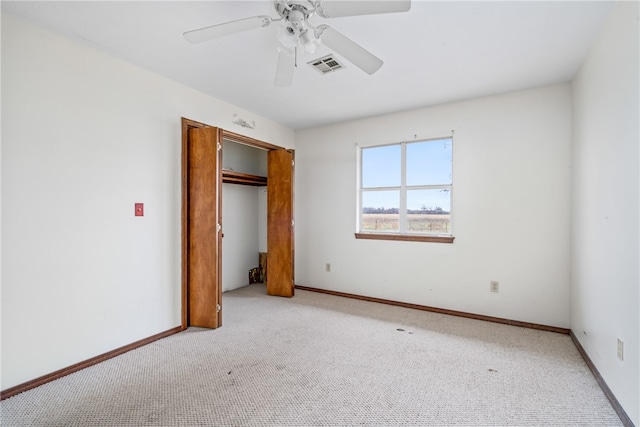 unfurnished bedroom featuring ceiling fan, light colored carpet, and a closet