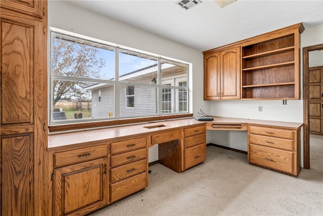 carpeted home office featuring built in desk