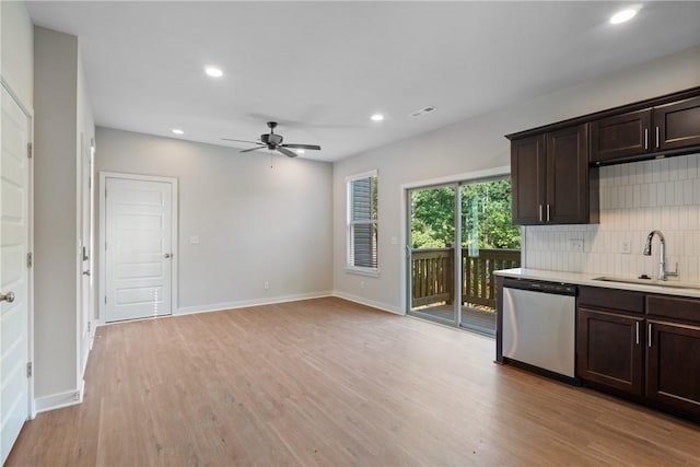 kitchen featuring tasteful backsplash, dishwasher, dark brown cabinets, light wood-style floors, and a sink