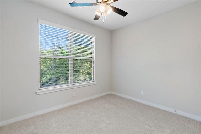 carpeted empty room with a ceiling fan and baseboards