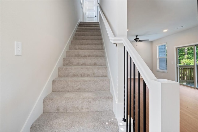 stairs with a ceiling fan and recessed lighting