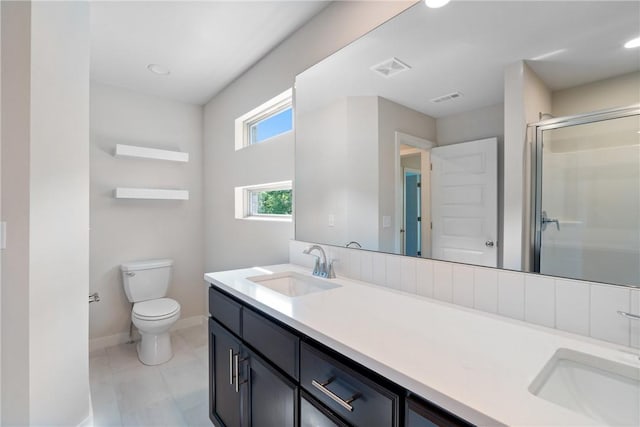 full bathroom with toilet, double vanity, a sink, and visible vents