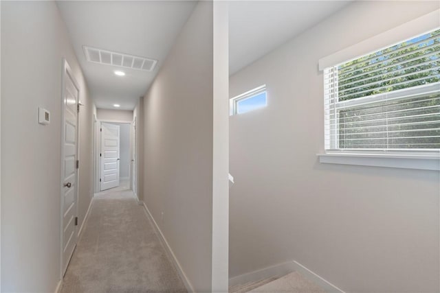 corridor featuring baseboards, recessed lighting, visible vents, and light colored carpet