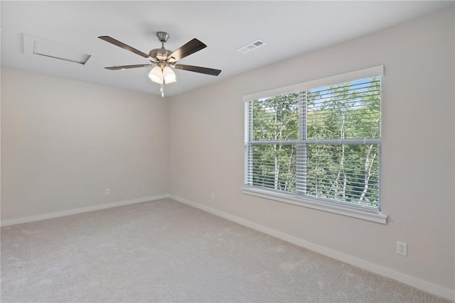 empty room featuring attic access, carpet flooring, visible vents, and baseboards