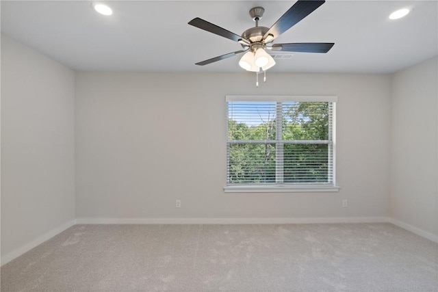 spare room with recessed lighting, light colored carpet, and baseboards