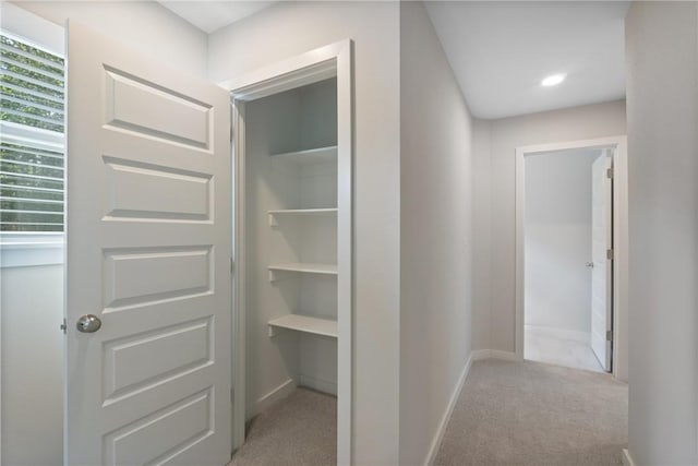 hallway with light carpet and baseboards