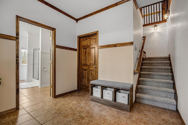 stairs with crown molding and tile patterned flooring