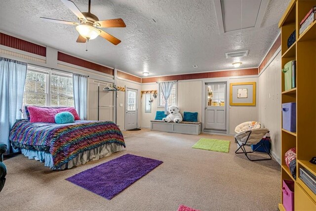 bedroom with carpet flooring, a textured ceiling, multiple windows, and ceiling fan