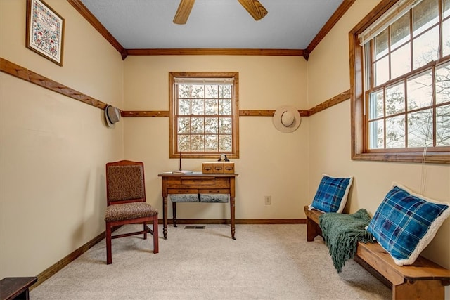 living area with ceiling fan, carpet floors, and crown molding