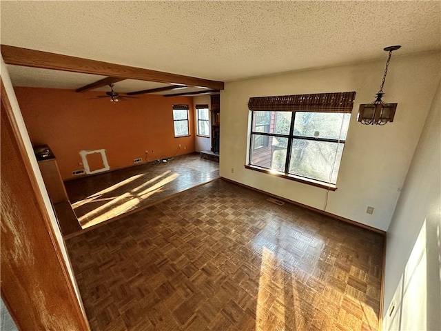 unfurnished living room with visible vents, a textured ceiling, beamed ceiling, baseboards, and ceiling fan with notable chandelier