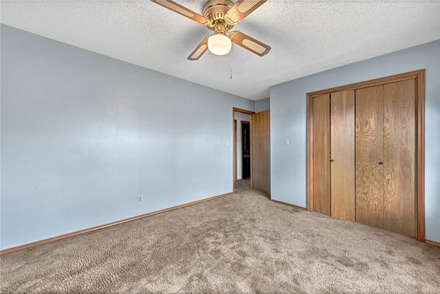 unfurnished bedroom with a closet, carpet flooring, ceiling fan, a textured ceiling, and baseboards