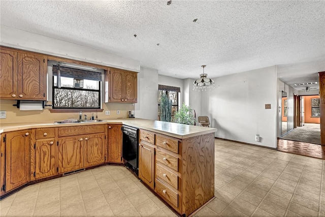 kitchen featuring a peninsula, a sink, light countertops, dishwasher, and light floors