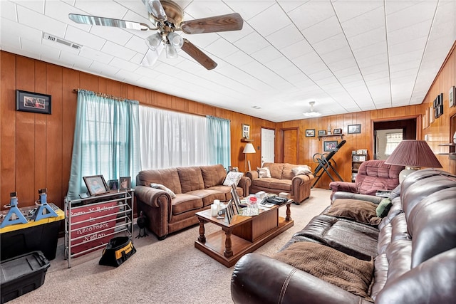 living room with light carpet, wooden walls, and ceiling fan