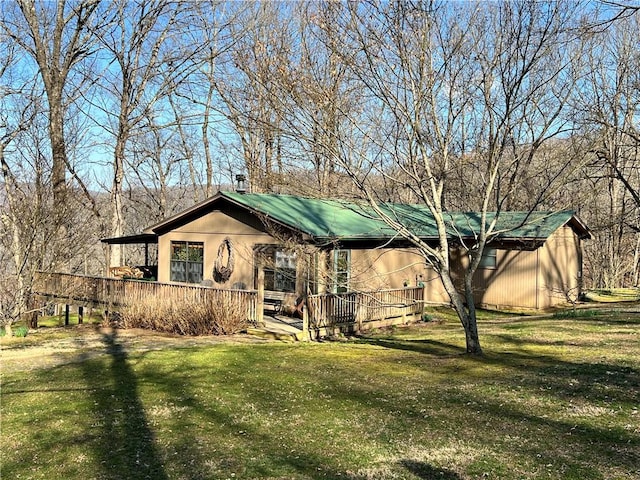 ranch-style home featuring a front yard and a wooden deck