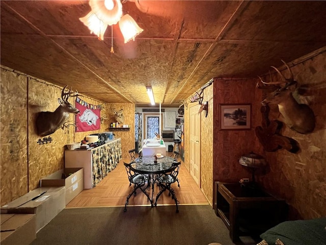 dining area featuring wooden ceiling, parquet floors, and wood walls