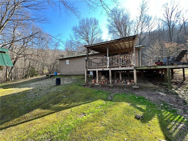 back of house with a deck and a lawn