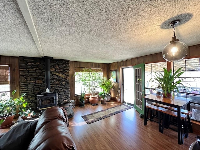 living room featuring wood walls, a wood stove, and hardwood / wood-style floors