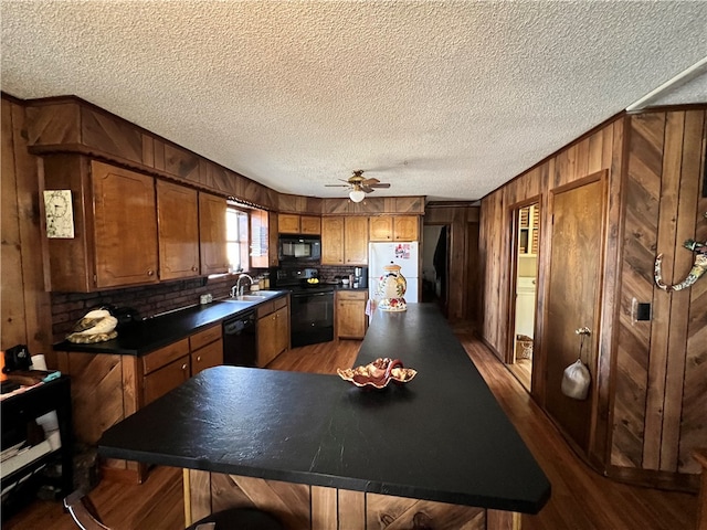 kitchen with ceiling fan, wood-type flooring, a textured ceiling, black appliances, and sink