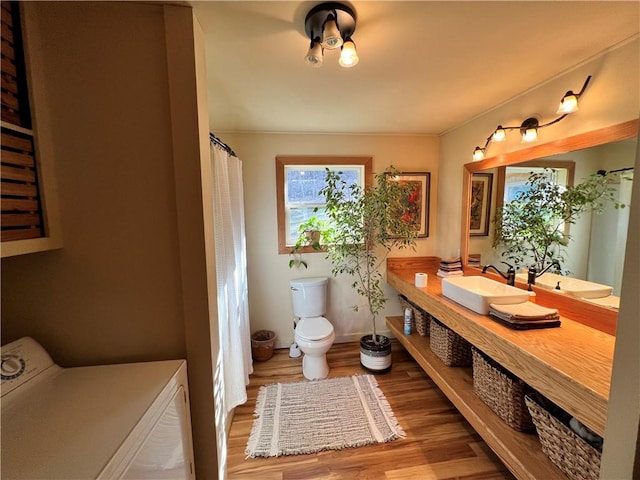 bathroom with toilet, wood-type flooring, washer / clothes dryer, and vanity