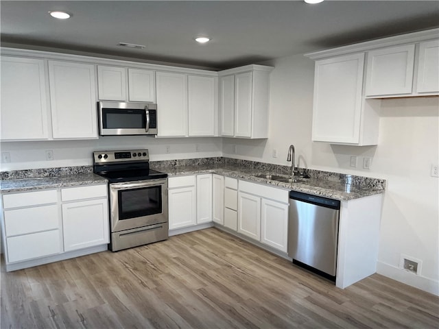 kitchen with white cabinets, light wood-type flooring, sink, and stainless steel appliances